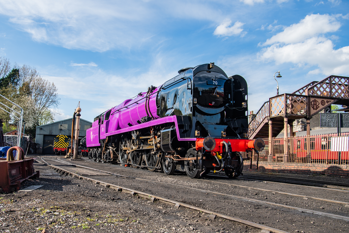 A purple locomotive in a siding